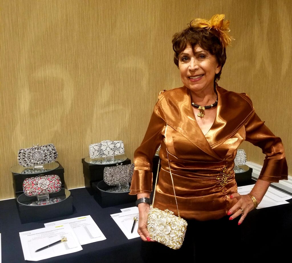 woman wearing velvet top with gold and white purse