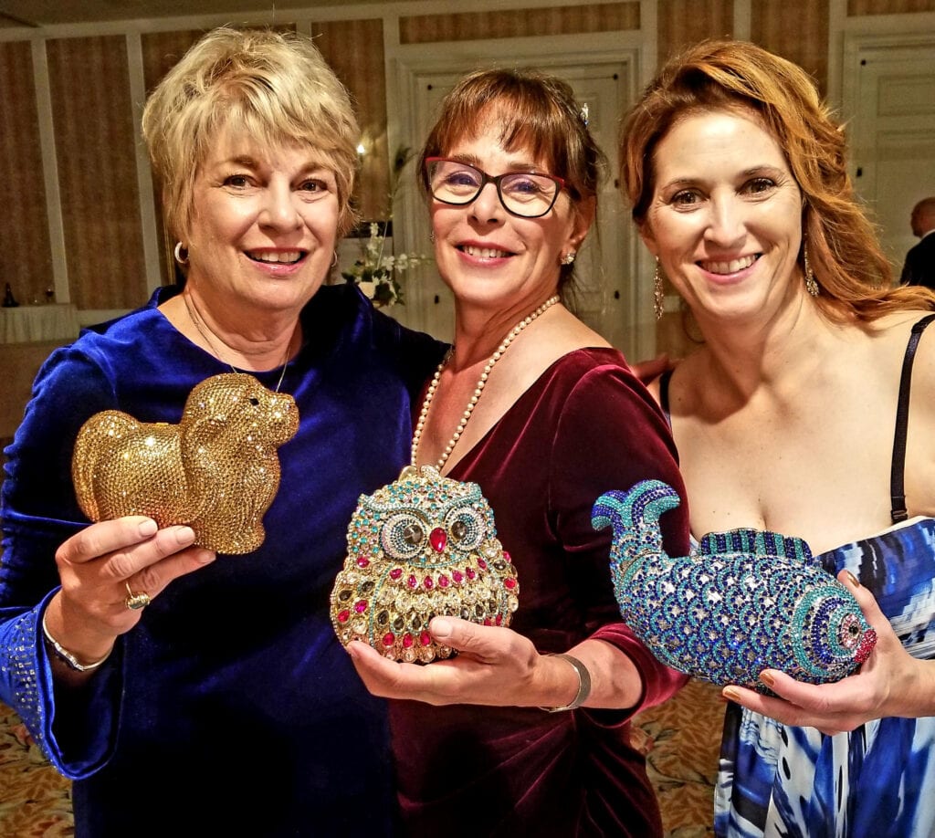 Women holding animal shaped Swarovski crystal purses