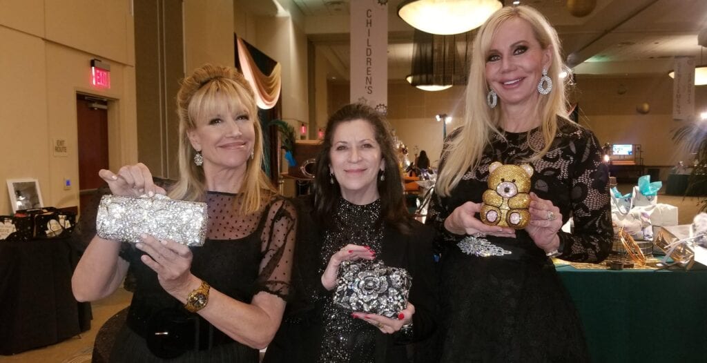 three women holding Swarovski crystal purses 2
