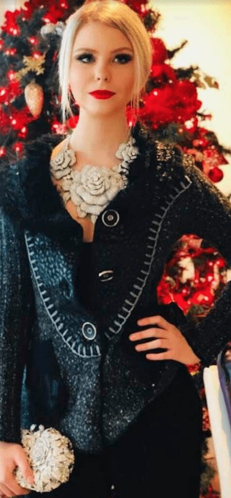 woman wearing a coat holding a silver round purse