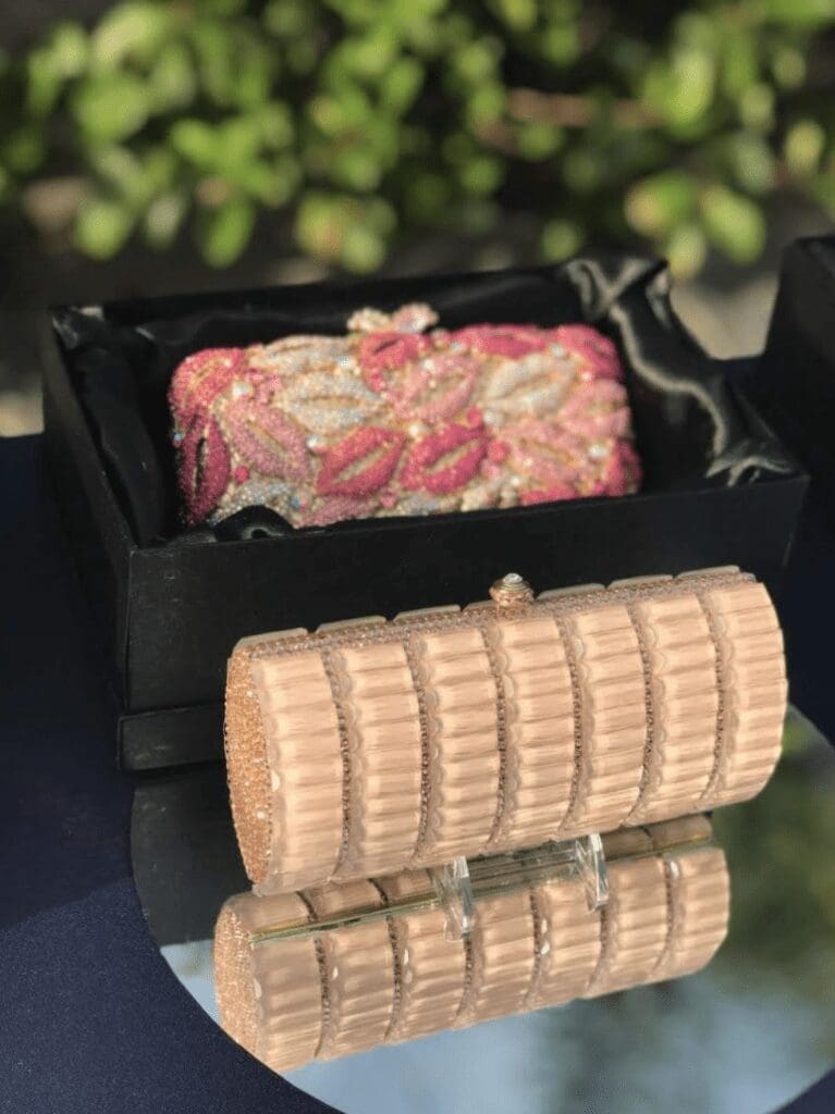 two Swarovski crystal purses on a glass table