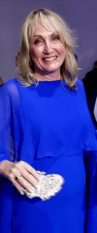woman wearing a blue dress with a silver Swarovski crystal purse
