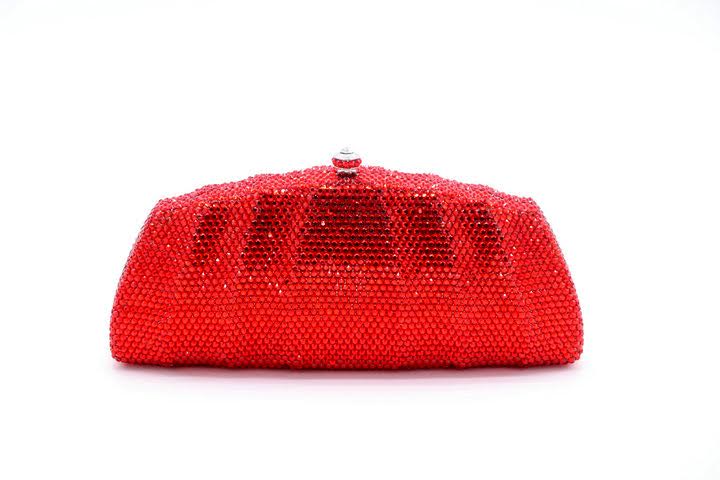 A vibrant red textured clutch purse with a rounded shape.