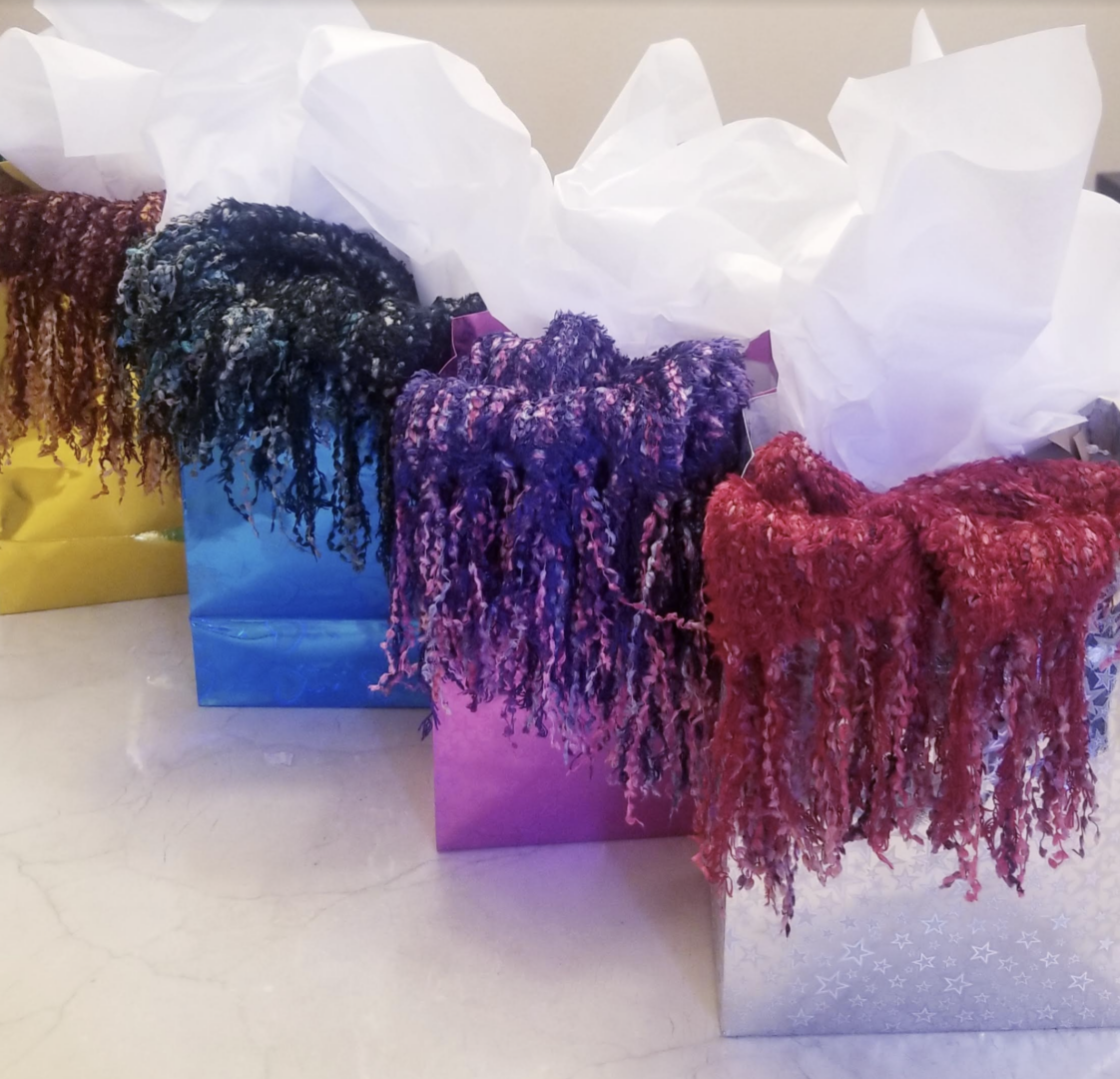Four colored scarves in gift bags