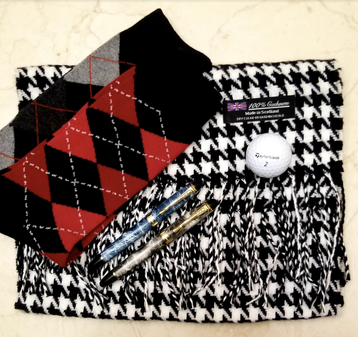flat lay of socks and cashmere scarf with pens and golf ball 4