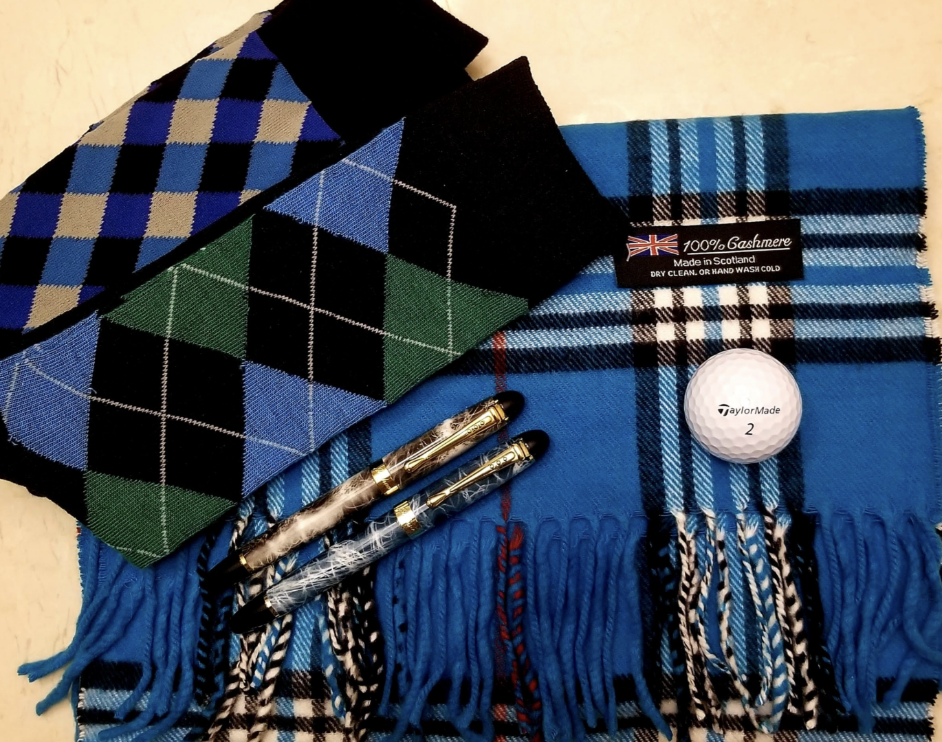flat lay of socks and cashmere scarf with pens and golf ball 3