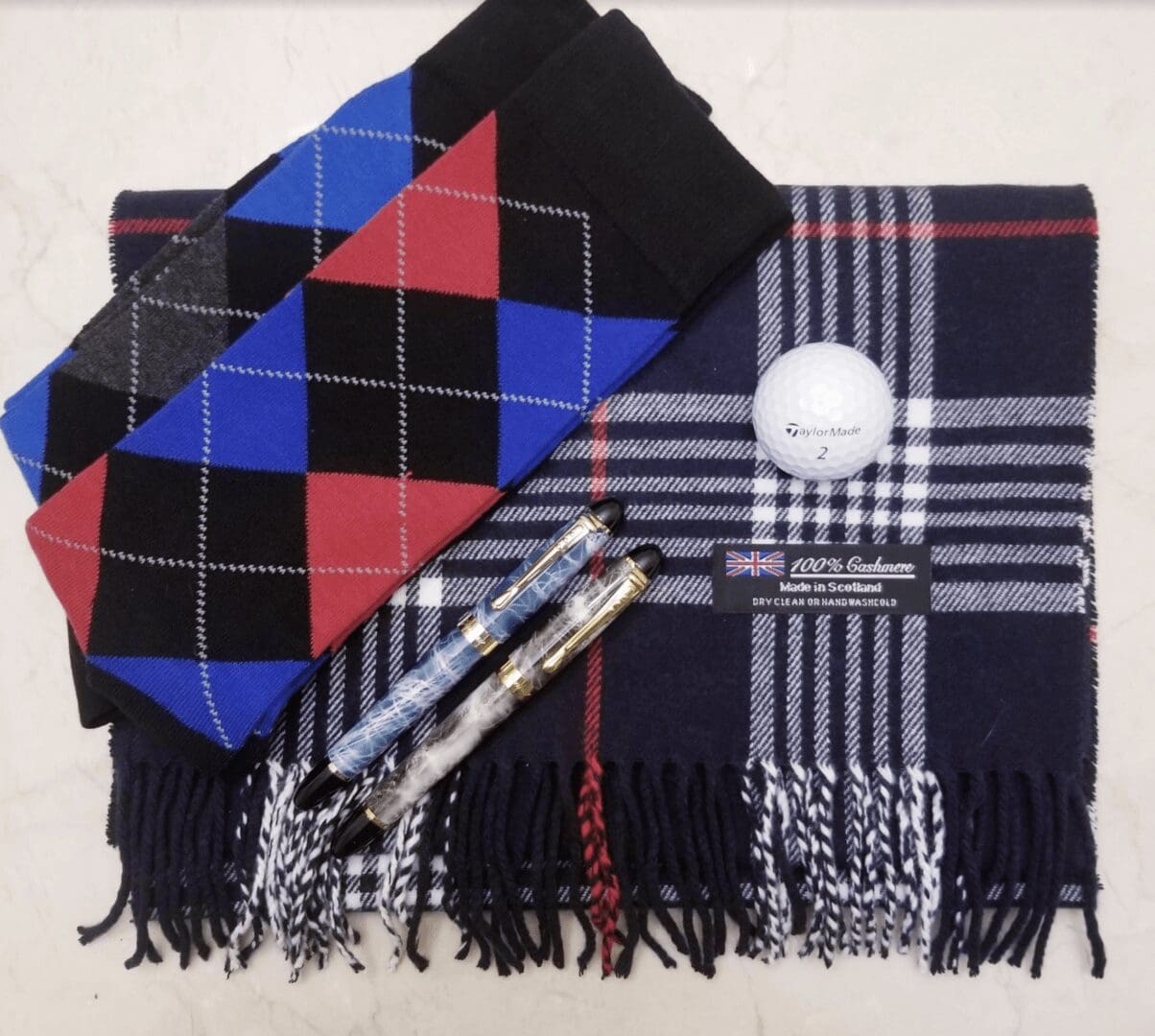 flat lay of socks and cashmere scarf with pens and golf ball